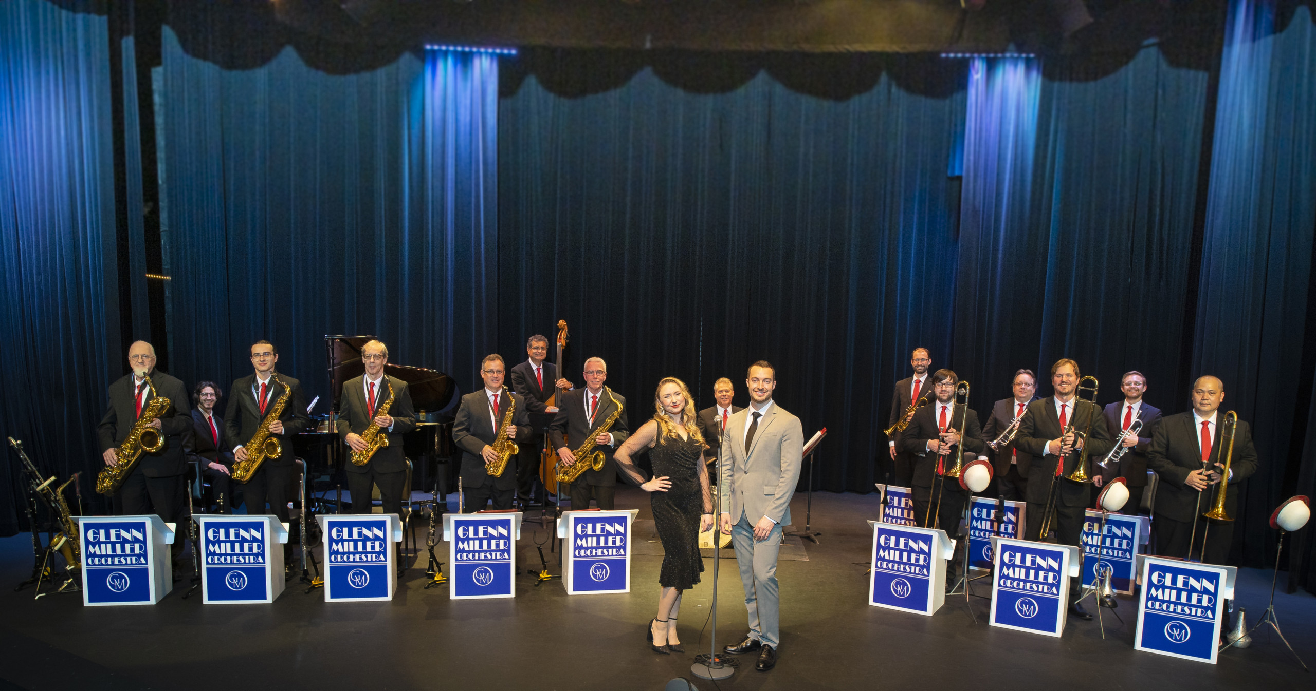 A big band ensemble on stage with blue 