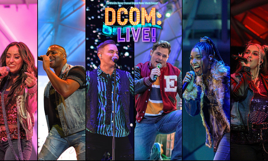 A lively concert scene with five performers singing energetically on stage. The vibrant 'DCOM Live!' logo is displayed above